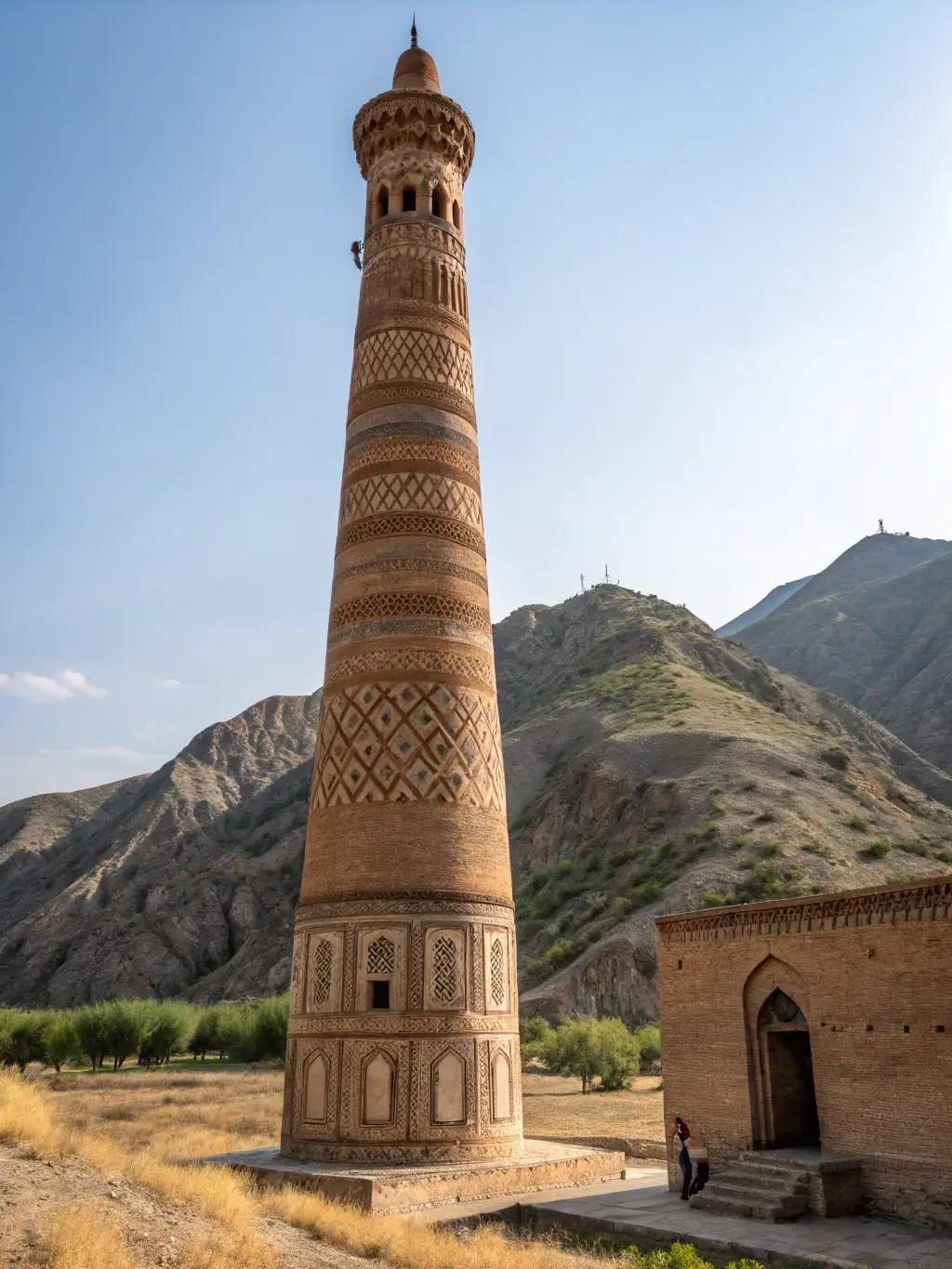 A scenic view of the Minaret of Jam, a UNESCO World Heritage site, standing tall amidst the rugged landscape of Herat.